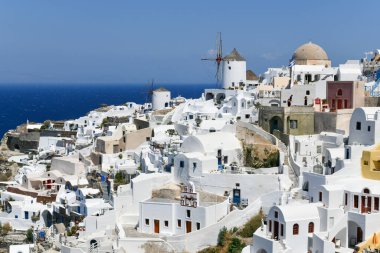 Yunanistan 'ın Santorini adasındaki Oia köyünün büyüleyici manzarası. Ege Denizi 'ndeki Caldera üzerinde geleneksel mavi kubbe kilisesi. Geleneksel mavi ve beyaz Cyclades mimarisi.