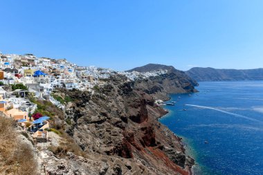 Yunanistan 'ın Santorini adasındaki Oia köyünün büyüleyici manzarası. Ege Denizi 'ndeki Caldera üzerinde geleneksel mavi kubbe kilisesi. Geleneksel mavi ve beyaz Cyclades mimarisi.