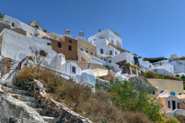 Yunanistan 'ın Santorini adasındaki Oia köyünün büyüleyici manzarası. Ege Denizi 'ndeki Caldera üzerinde geleneksel mavi kubbe kilisesi. Geleneksel mavi ve beyaz Cyclades mimarisi.