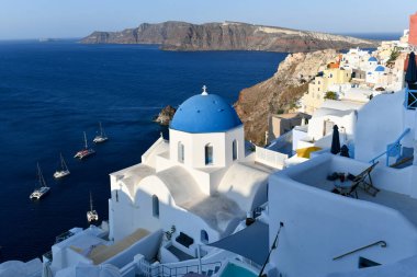 Yunanistan 'ın Santorini adasındaki Oia köyünün büyüleyici manzarası. Ege Denizi 'ndeki Caldera üzerinde geleneksel mavi kubbe kilisesi. Geleneksel mavi ve beyaz Cyclades mimarisi.