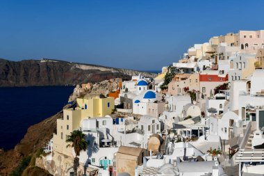 Yunanistan 'ın Santorini adasındaki Oia köyünün büyüleyici manzarası. Ege Denizi 'ndeki Caldera üzerinde geleneksel mavi kubbe kilisesi. Geleneksel mavi ve beyaz Cyclades mimarisi.