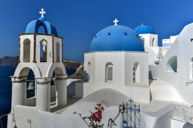 Yunanistan 'ın Santorini adasındaki Oia köyünün büyüleyici manzarası. Ege Denizi 'ndeki Caldera üzerinde geleneksel mavi kubbe kilisesi. Geleneksel mavi ve beyaz Cyclades mimarisi.