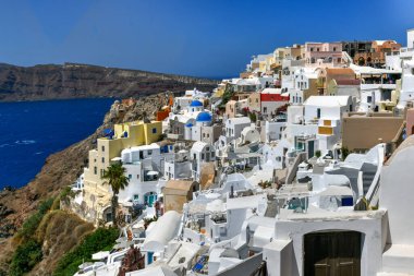 Yunanistan 'ın Santorini adasındaki Oia köyünün büyüleyici manzarası. Ege Denizi 'ndeki Caldera üzerinde geleneksel mavi kubbe kilisesi. Geleneksel mavi ve beyaz Cyclades mimarisi.