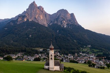 St. Valentin (Kastelruth) Village Church in the summer in the Dolomite Alps. Amazing landscape with small chapel on sunny meadow and Petz peak at Kastelruth commune. Dolomites, South Tyrol, Italy