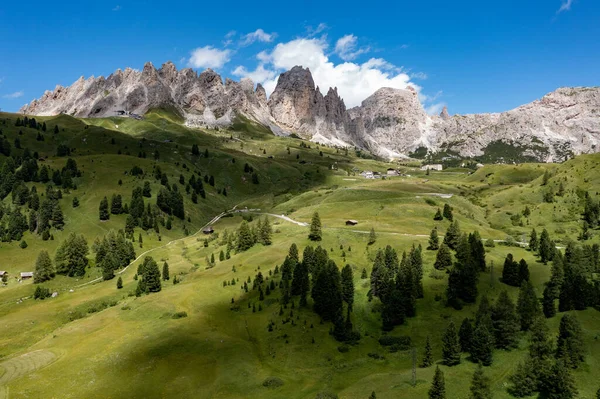 Colors of the Dolomites in the Funes view of the valley in Southern Tyrol, Italy. Green grass, mountains and blue sky. Summer.