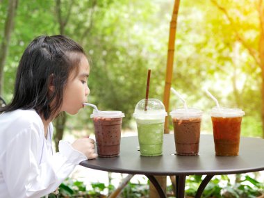 Çocuğun yan resmi ormanın arka bahçesinde içme suyu içerken çekilmiş.