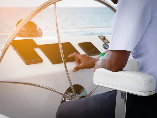 Tekne kaptanı sarı ışık arka planlı tekneyi kontrol ediyordu.