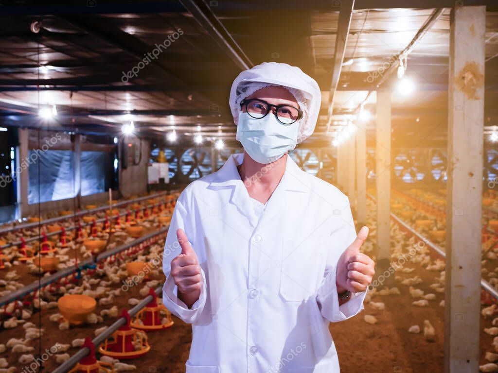 The woman in white suit with feeling happy and thumb up with chicken farmimg backround and yellow light.