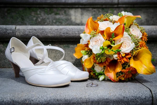 Wedding bouquet in autumn colors, white bride's shoes and rings on stairs — Stock Photo, Image