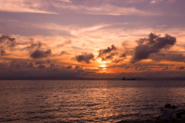 Pembe gün batımı gökyüzü ve denizin üzerinde güzel bulutlar.