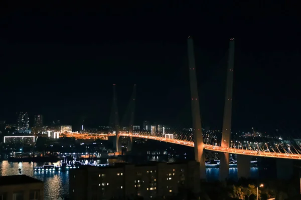 Vladivostok Golden Bridge over Golden Horn baai met skyline nachtzicht verlicht met lichten van de stad — Stockfoto