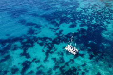 aerial view of a clear sea sea with a white boat