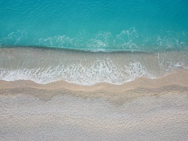 Aerial view of beautiful sea waves on a sandy beach