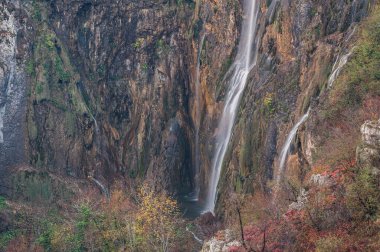 Plitvice Gölleri Ulusal Parkı 'ndaki sonbahar manzarasında büyük bir şelalenin görkemli manzarası