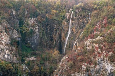 Plitvice Gölleri Ulusal Parkı 'ndaki sonbahar manzarasında büyük bir şelalenin görkemli manzarası