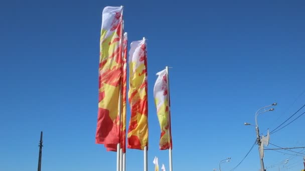 Feestelijke vlaggen zwaaien in de wind tegen een blauwe hemel — Stockvideo