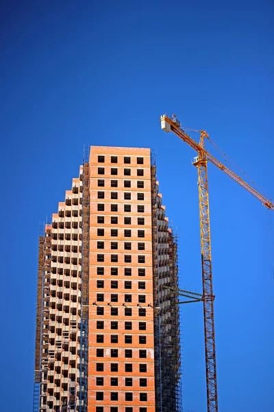 Costruzione di un edificio a più piani con una gru — Foto Stock