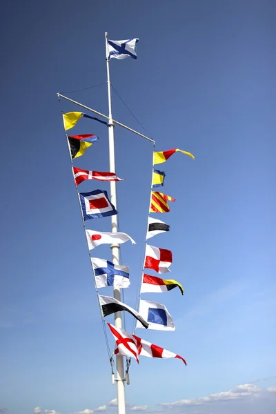 Marine flags of different countries on a mast — Stock Photo, Image