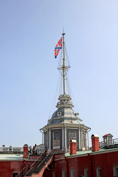 Spire with the flag in the Peter and Paul Fortress in St. Peters — Stock Photo, Image