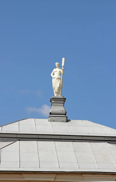 Sculpture nude woman with a paddle on the roof — Stock Photo, Image