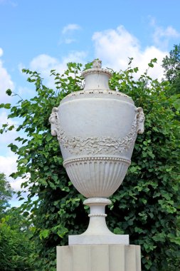 parkta bir taş kaide üzerinde antik mermer amphora