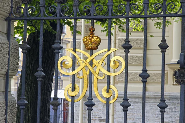 Gesmeed grille met het koninklijk monogram in Sint-petersburg, Rusland — Stockfoto