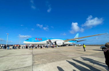 Bridgetown, Barbados - 25 Mart 2022: TUI Boeing 787 Dreamliner 'dan inen yolcular, Plakası G-TUIO, Bridgetown Havaalanı kapısında.
