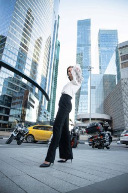 Siyah beyaz gökdelenleri olan genç bir iş kadını.