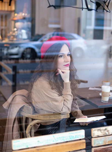 Красивая Женщина Вьющимися Волосами Красном Французском Берете Окном Кафе — стоковое фото