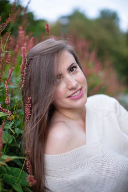 Beyaz süveter giyen, siyah gözlü beyaz bir kadın.