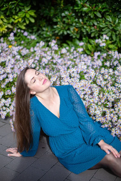 Relajante Mujer Europea Joven Blanca Con Flores Detrás Azul Brillante — Foto de Stock