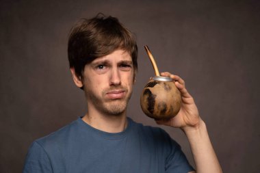 Kahverengi saçlı, uzun boylu, zayıf beyaz bir adam gri arka planda gri gömleği görünce hayal kırıklığına uğradı.