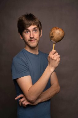 Kahverengi saçlı, uzun boylu, zayıf beyaz bir adam gri arka planda gri gömlekli kameraya bakan eş fincan.