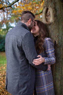 Sonbaharda ağacın yanında beyaz adam ve kadını kucaklamak.