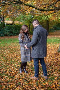 Sonbahar ormanlarında genç Avrupalı beyaz erkek ve kadınları kucaklayan romantik bir aşk.