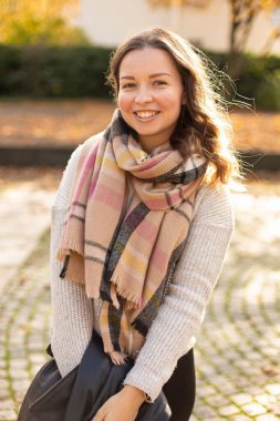 Gülümseyen Avrupalı beyaz kadın portresi Sonbaharda yürüyen kahverengi saçlı