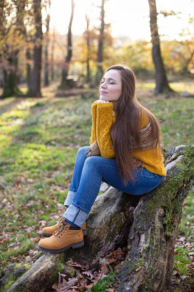Śniąca Biała Młoda Europejka Żółtym Swetrze Siedząca Korzeniach Drzew Słonecznym — Zdjęcie stockowe