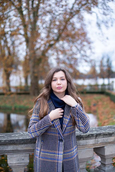 秋天公园里穿着风衣的年轻女子的画像 — 图库照片