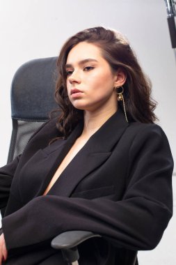 Ofisinde beyaz tenli, uzun siyah saçlı Avrupalı genç bir kızın portresi