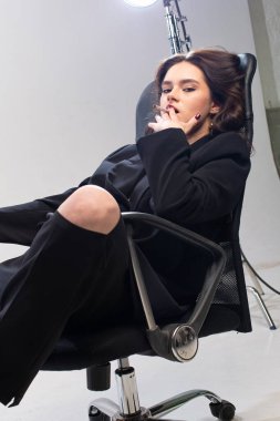 Beyaz tenli, oturan ve sigara içen genç Avrupalı kız