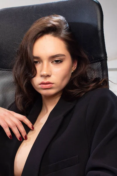 黒椅子オフィスで白い肌を持つ暗い髪若いヨーロッパの女の子の肖像画 — ストック写真
