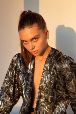 Gün batımında siyah saçlı, beyaz tenli, at kuyruklu, bej bir portrede izole edilmiş bir kadın.