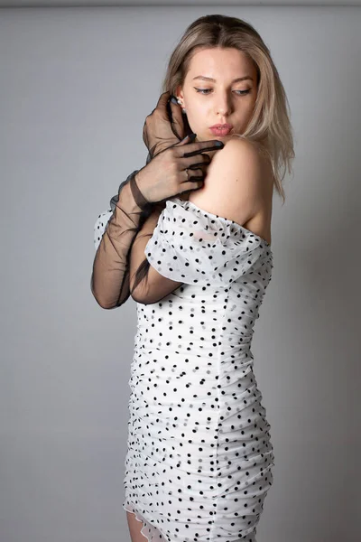 ブロンド髪と白い肌を持つ女性絶縁オンダークグレーでポルカドットドレス — ストック写真