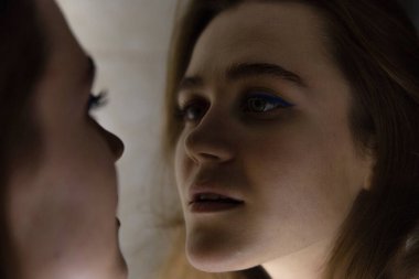 Aynada beyaz tenli genç bir kadının portresi