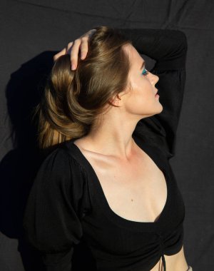 Gözünü kaçıran beyaz tenli, koyu kahverengi yakalı genç bir kadın.