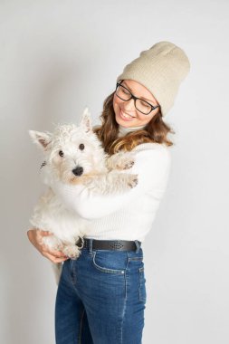 Gözlüklü, beyaz kazaklı, köpekli çekici bir Avrupalı kadın.