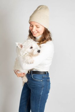 Ilık beyaz kazaklı çekici Avrupalı kadın bir köpekle beyaz üzerine izole edilmiş.