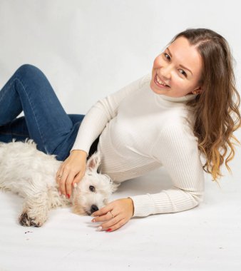 Ilık beyaz kazaklı çekici Avrupalı kadın beyaz evcil köpeğe izole edilmiş.