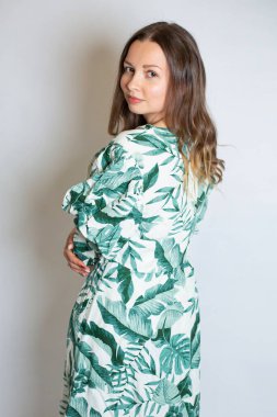 Gri renkte izole edilmiş çiçek desenli elbiseli çekici Avrupalı kadın.