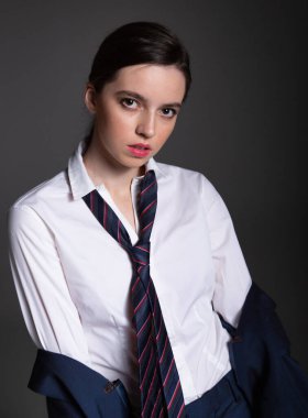 İş stili Avrupalı beyaz gömlekli, siyah kravatlı genç kadın portresi.